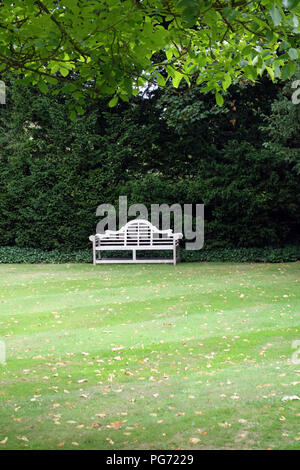 A traditionally shaped Lutyens 3 seater bench made from Cornis hardwood in a Large English country house in Nottinghamshire. Stock Photo