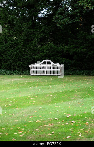 A traditionally shaped Lutyens 3 seater bench made from Cornis hardwood in a Large English country house in Nottinghamshire. Stock Photo