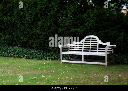 A traditionally shaped Lutyens 3 seater bench made from Cornis hardwood in a Large English country house in Nottinghamshire. Stock Photo