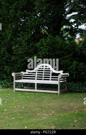 A traditionally shaped Lutyens 3 seater bench made from Cornis hardwood in a Large English country house in Nottinghamshire. Stock Photo