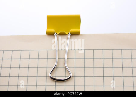 Colored paper clip on a checked notebook  page Stock Photo