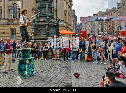 EDINBURGH FESTIVAL FRINGE 2018 A  JUGGLER WITH FIREBRANDS AND A BLADE BALANCING ON LARGE WOODEN SPOOLS Stock Photo