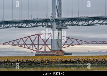 FORTH RAILWAY BRIDGE OVER THE FIRTH OF FORTH SCOTLAND AND THE OLD ROAD BRIDGE UNDERGOING REPAIR Stock Photo