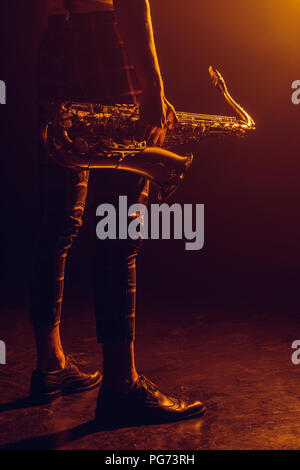 cropped shot of stylish musician holding saxophone Stock Photo