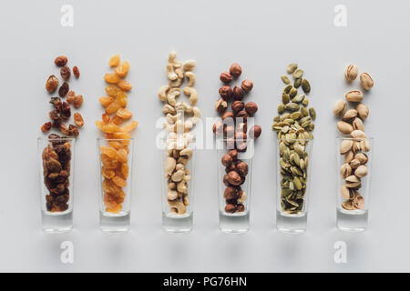 Assorted delicious nuts and raisins in glass cups isolated on white background Stock Photo