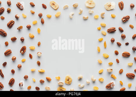 top view of dried fruits and nuts with copy space in center isolated on white background Stock Photo
