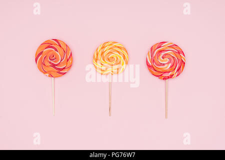 top view of three round lollipops isolated on pink Stock Photo