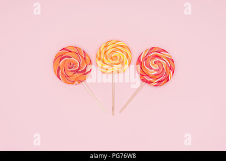 top view of three round yummy lollipops isolated on pink Stock Photo