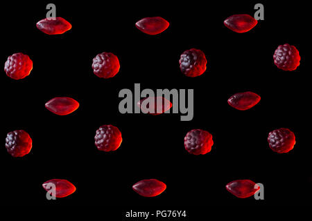 set of red jelly candies in shape of raspberries and lips isolated on black Stock Photo