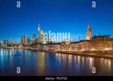 View of Frankfurt am Main skyline at dusk along Main river with cruise ship in Frankfurt, Germany Stock Photo