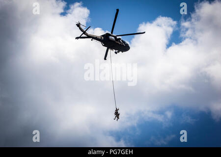 U.S. Air Force tactical air control party Airmen with the 227th Air Support Operations Squadron, New Jersey Air National Guard, demonstrate a special extraction system as they hang from a UH-60L Black Hawk helicopter with the 1st Assault Helicopter Battalion, 150th Aviation, New Jersey Army National Guard, during the 2018 Atlantic City International Airshow “Annual Thunder Over The Boardwalk” at Atlantic City, N.J., Aug. 22, 2018. The 150th is located at Joint Base McGuire-Dix-Lakehurst, while the 227th is located at the Atlantic City Air National Guard Base. (New Jersey National Guard photo b Stock Photo