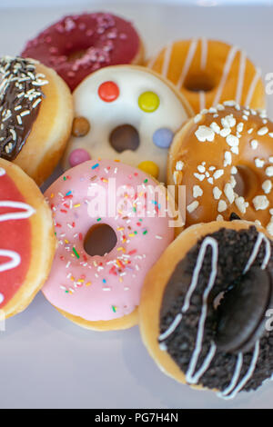 a close up on a selection of tasty iced ring doughnuts Stock Photo