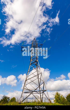 power line tower on the hill. view from below. beautiful blue sky with clouds Stock Photo