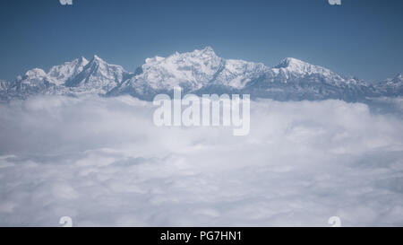 The Himalayas as seen from an airplane in Nepal. Layer of clouds beneath the mountain tops. Stock Photo