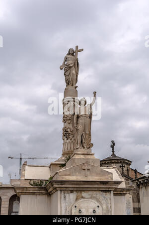 Sculpture of Jesus and angel on crypt in Poblenou Cemetery. Peaceful but macabre, cemetery of Poblenou is today home to incredible sculptures Stock Photo