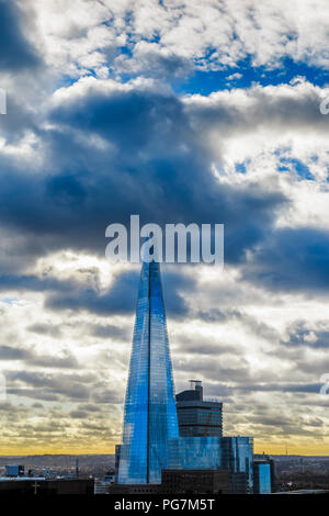 View from the City of London of the Shard, London's tallest building, with gathering dark storm clouds at sunset, London Borough of Southwark SE1 UK Stock Photo