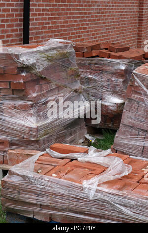 new reclaimed hand made red bricks on site Stock Photo