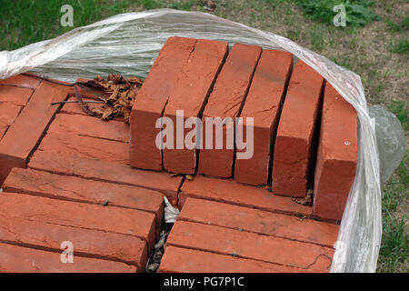 new reclaimed hand made red bricks on site Stock Photo