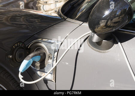 Electrci car charging - Close up of a power socket on grey electric car, recharging batteries. Stock Photo