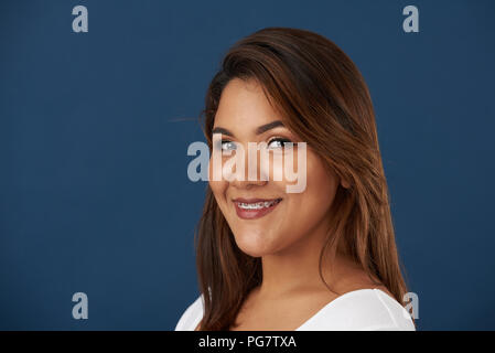 Headshot of girl with braces on blue studio background Stock Photo
