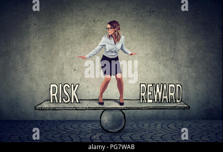 Skillful young business woman balancing between reward and risk in challenging corporate environment Stock Photo