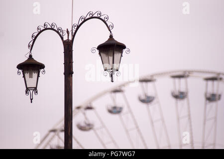 Old fashioned street lamp with ferris wheel in background Stock Photo