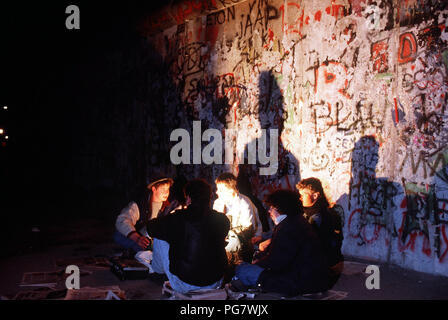 Berlin Wall 1989 - Young visitors to the Berlin Wall hold a candlelight vigil to celebrate the demolition of a section of the Wall at Potsdamer Platz. Stock Photo