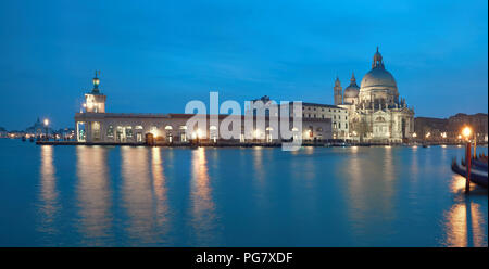 Illuminated Punta della Dogana and church Santa Maria della Salute in Venice, Italy. Panoramic image taken in the evening. Stock Photo