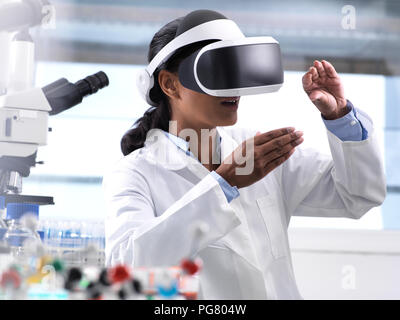 Female scientist using virtual reality to understand a research experiment in the laboratory Stock Photo