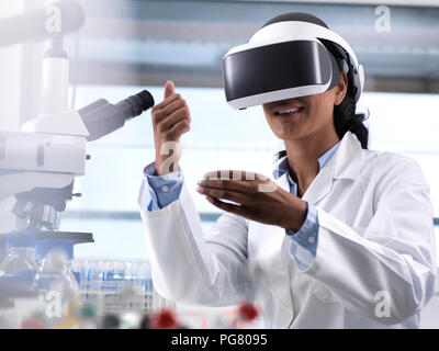 Female scientist using virtual reality to understand a research experiment in the laboratory Stock Photo