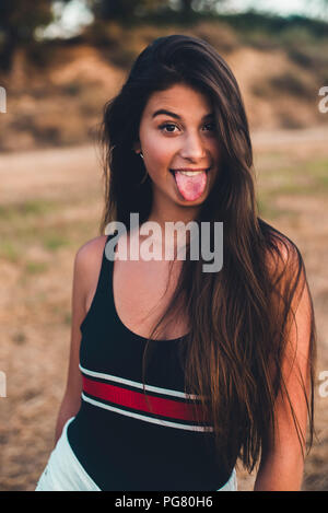 Portrait of teenage girl sticking out tongue Stock Photo