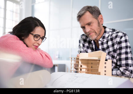 Smiling colleagues looking at architectural model in office Stock Photo