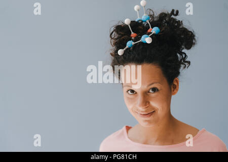 Young woman with molecule model in her hair Stock Photo