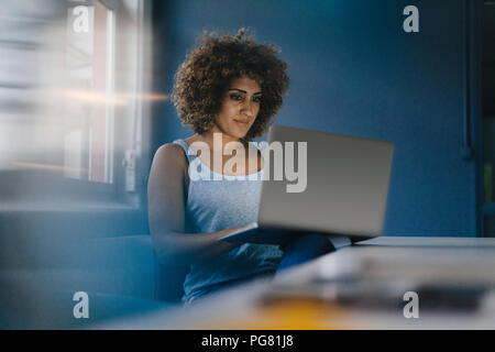 Woman working overtime in her start-up business Stock Photo