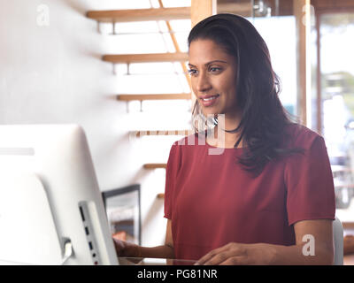Portrait of smiling businesswoman using computer in office