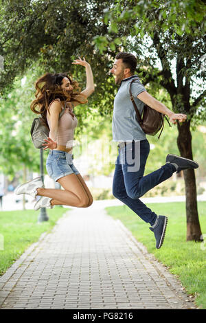 Carefree couple jumping in park Stock Photo