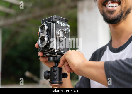 Close-up of happy young man using vintage camera Stock Photo