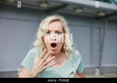 Portrait of shocked woman outdoors Stock Photo