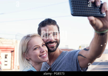 Happy young man with girlfriend taking a selfie Stock Photo