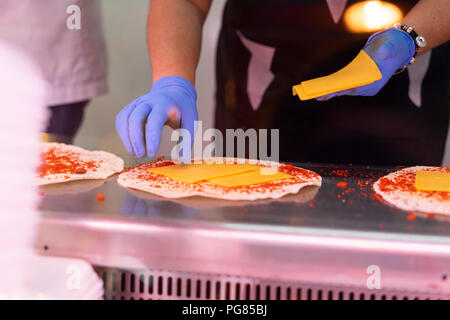 Woman in market stall filling tortilla wraps Stock Photo