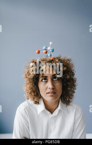 Young woman with molecule model in her hair Stock Photo