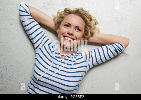 Portrait of happy woman with hands behind head Stock Photo
