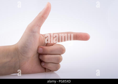 Hand making a gun gesture on a white background Stock Photo
