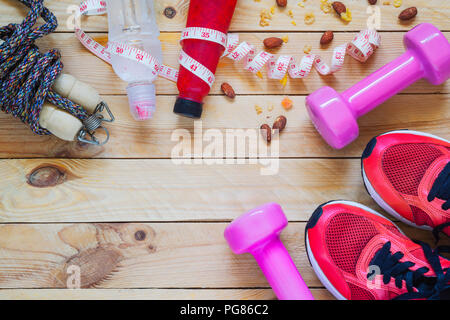 Body Care and Beauty, Weight and Dieting Healthy lifestyle concept. Sport equipment, Dumbbells, running shoes, skipping ropes on wooden background. Stock Photo