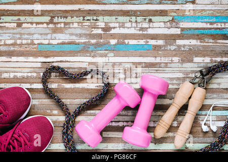 Weight and Dieting Fit and Beauty Healthy lifestyle concept. Sport equipment, Dumbbells, running shoes, skipping ropes on wooden background. Stock Photo