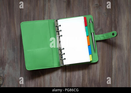 Open blank green organizer book on wood background top view with blank space for your text Stock Photo