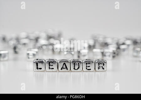 Leader word written on silver cube  with black and white bokeh cube word block background Stock Photo