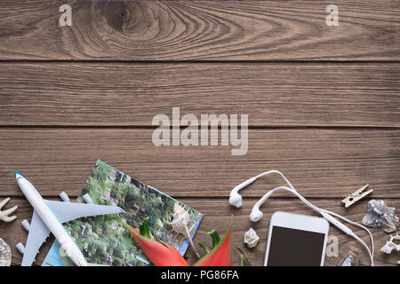 Vacation travel summer tropical Island weekend adventure trip concept top view with copy space. Seashell, miniature toy plane, tropical flower, smartp Stock Photo