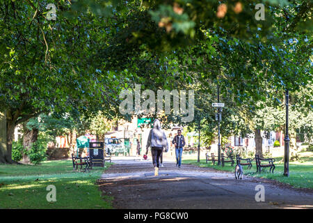 Northampton. U.K. 24th August 2018. A female taking her dog for a morning walk in Abington Park, temperatures were in single figures last night making it feel much colder this morning . Credit: Keith J Smith./Alamy Live News Stock Photo