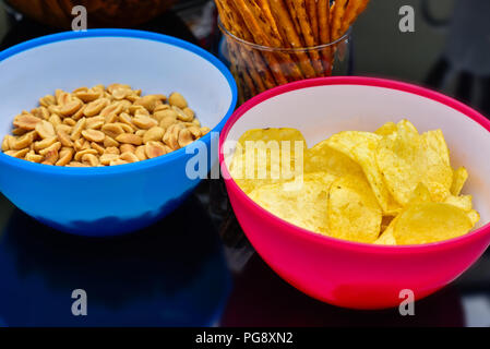 Potato chips or nuts in plastic bowl on a dark background Stock Photo